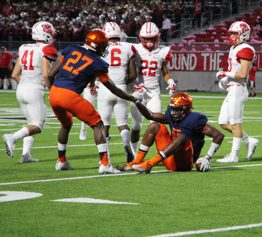 Player Keilan Johnson helps fellow teammate David Ugwoegbu get back up. The players demonstrated leadership throughout the game. 