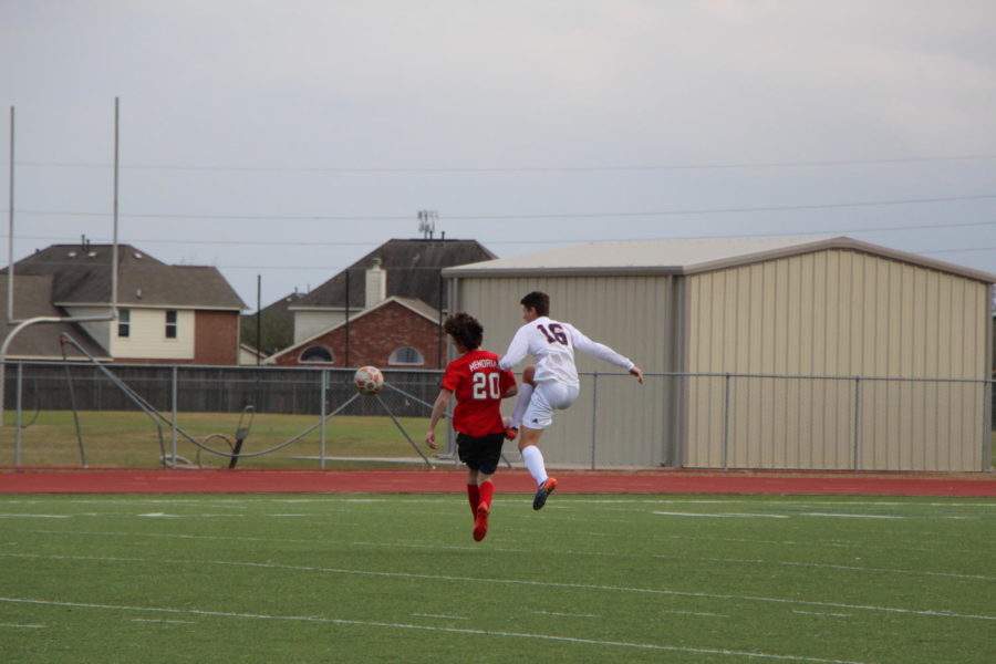 Isaac Peterson and an opposing player both move towards the ball.