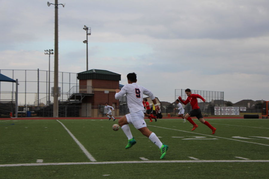 Raul Ekmeiro sprints to the ball to maintain possession.